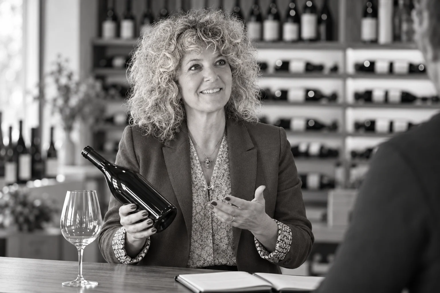 Nadine Rosier presenting a bottle in a wine shop scene